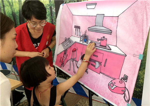 Una chica intenta identificar peligros potenciales en una cocina durante una clase sobre seguridad impartida en Shanghai. (Foto: Zhou Wenting)