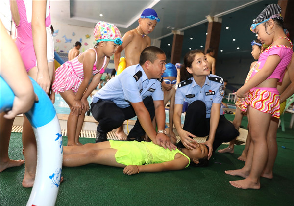 Oficiales de policía enseñan a los niños cómo resucitar a un ahogado, Zhengzhou, provincia de Henan. (Foto: Liu Shutting/ China Daily)
