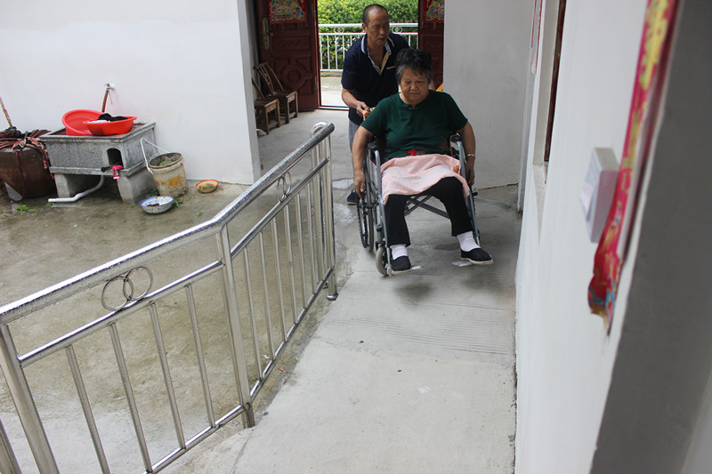 Yang Chuansheng conduce la silla de ruedas de su esposa a través de una rampa que facilita la salida de la casa. (Foto: China Daily)