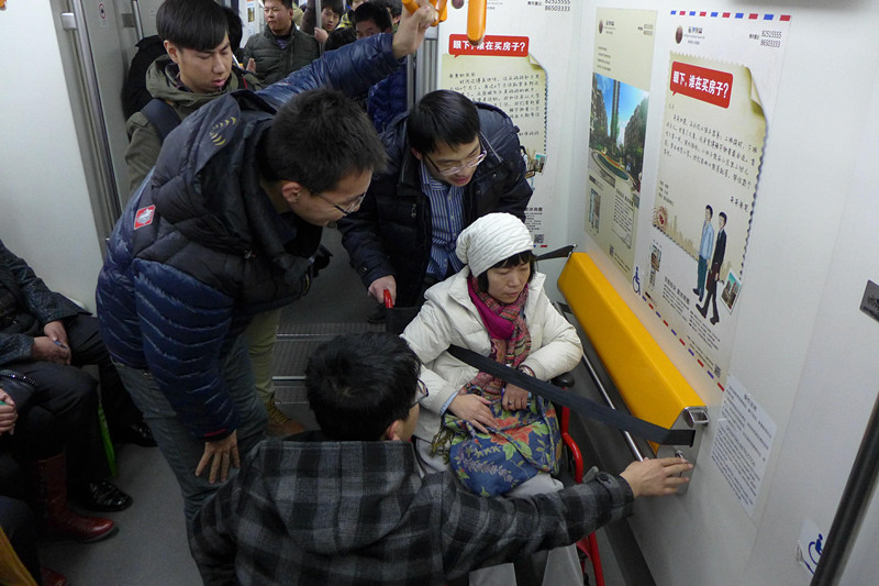 Voluntarios ayudan a una señora discapacitada en el metro de Shenyang, provincia de Liaoning. (Foto: Zhao Jingdong/ China Daily)