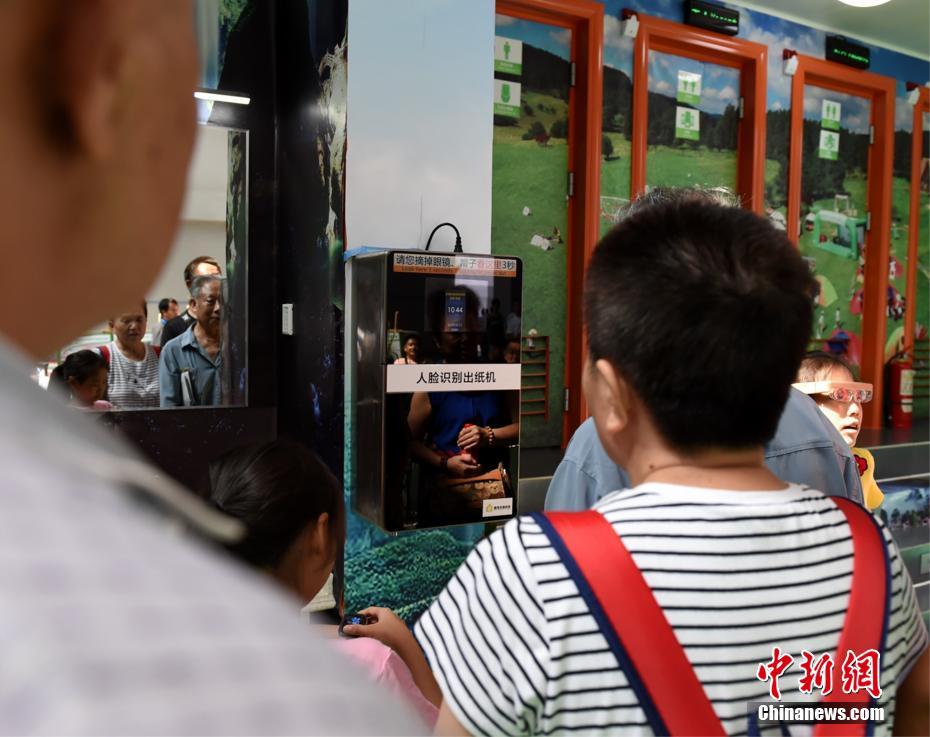 Los ciudadanos prueban la máquina de papel con reconocimiento facial. (Foto: Zhou Yi)