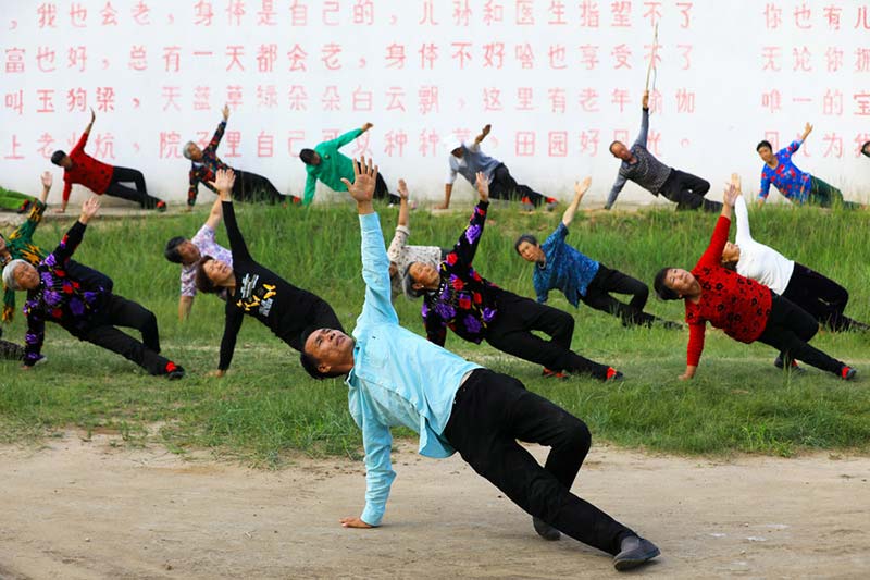 Lu Wenzhen, primer secretario de la aldea Yugouliang, lidera la práctica del "Yoga de Yugouliang ". [Foto: Zhu Xingxin/China Daily]