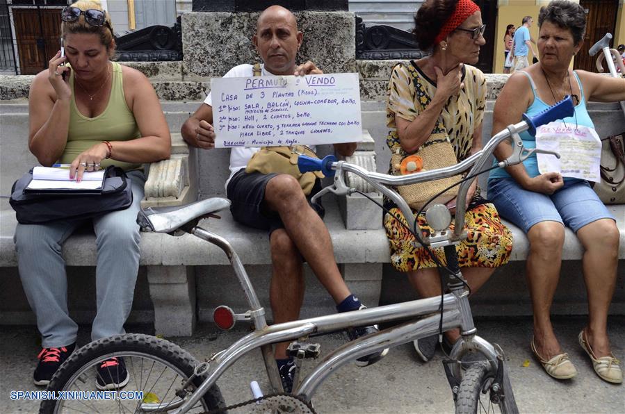 LA HABANA, octubre 7, 2018 (Xinhua) -- Imagen del 6 de octubre de 2018, de un hombre sosteniendo un cartel que promueve la venta o permuta de una vivienda, en la Bolsa de Permuta de Prado, en La Habana, Cuba. La conocida Bolsa de Permuta de Prado es un espontáneo lugar de intercambio de casas ubicado en el Paseo del Prado, una de las más viejas avenidas de la capital cubana. Allí, bajo la sombra de frondosos árboles, cientos de personas se dan cita todos los fines de semana en un informal mercado de viviendas donde, con carteles escritos a mano, muchos promueven los inmuebles que ofrecen y lo que necesitan. Los llamados "corredores de permutas" o "permuteros", como también se les conoce popularmente, son personas que se dedican a gestionar los intercambios de vivienda y cobran por esos servicios una parte del dinero involucrado en la transacción. (Xinhua/Joaquín Hernández)