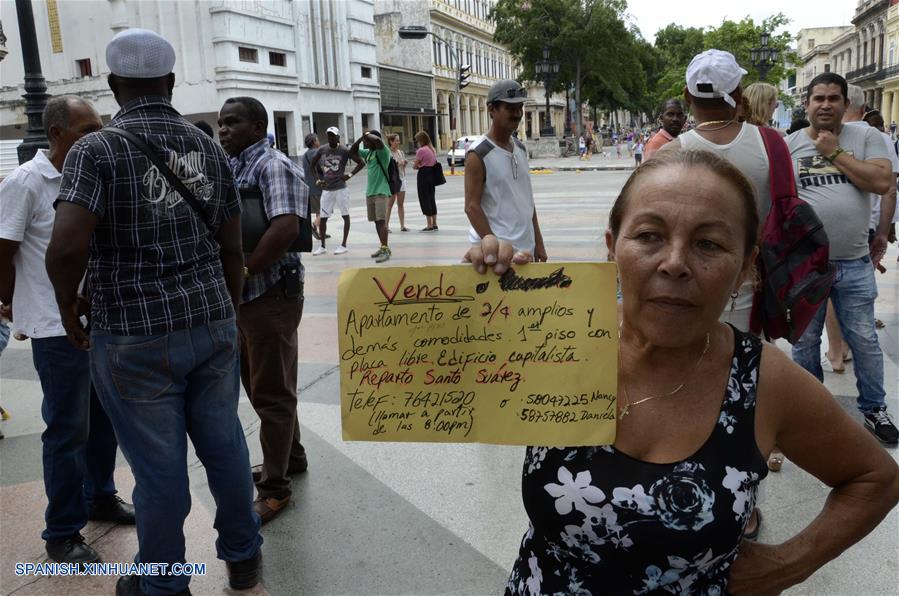 LA HABANA, octubre 7, 2018 (Xinhua) -- Imagen del 6 de octubre de 2018, de una mujer mostrando un cartel que promueve la venta de una vivienda, en la Bolsa de Permuta de Prado, en La Habana, Cuba. La conocida Bolsa de Permuta de Prado es un espontáneo lugar de intercambio de casas ubicado en el Paseo del Prado, una de las más viejas avenidas de la capital cubana. Allí, bajo la sombra de frondosos árboles, cientos de personas se dan cita todos los fines de semana en un informal mercado de viviendas donde, con carteles escritos a mano, muchos promueven los inmuebles que ofrecen y lo que necesitan. Los llamados "corredores de permutas" o "permuteros", como también se les conoce popularmente, son personas que se dedican a gestionar los intercambios de vivienda y cobran por esos servicios una parte del dinero involucrado en la transacción. (Xinhua/Joaquín Hernández)