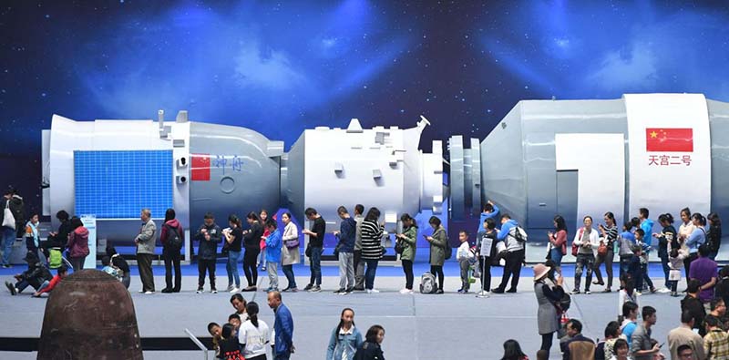 Visitantes hacen cola para probar juegos simulados del modelo de nave espacial Tiangong-2 durante una exposición de aeronáutica celebrada en Kunming, capital de la provincia de Yunnan. [Foto: Servicios de Noticias de China]