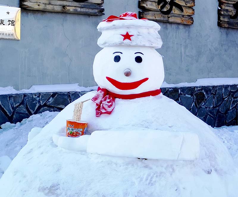 Un muñeco de nieve recibe a los visitantes en la Aldea Ártica, la atracción turística más famosa de Mohe. Aquí un gran número de visitantes disfrutan de los encantos del hielo y de la espesa nieve. [Foto: Chu Fuchao/ Chinadaily.com.cn]