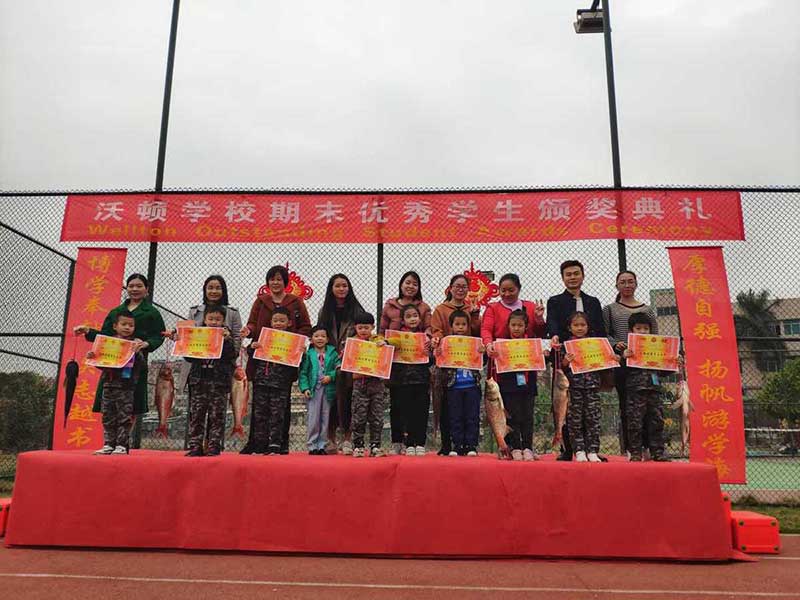 Los estudiantes reciben peces vivos como recompensa por su arduo estudio en la escuela de idioma Wellton, Dongguan, provincia de Guangdong. [Foto: proporcionada a chinadaily.com.cn]