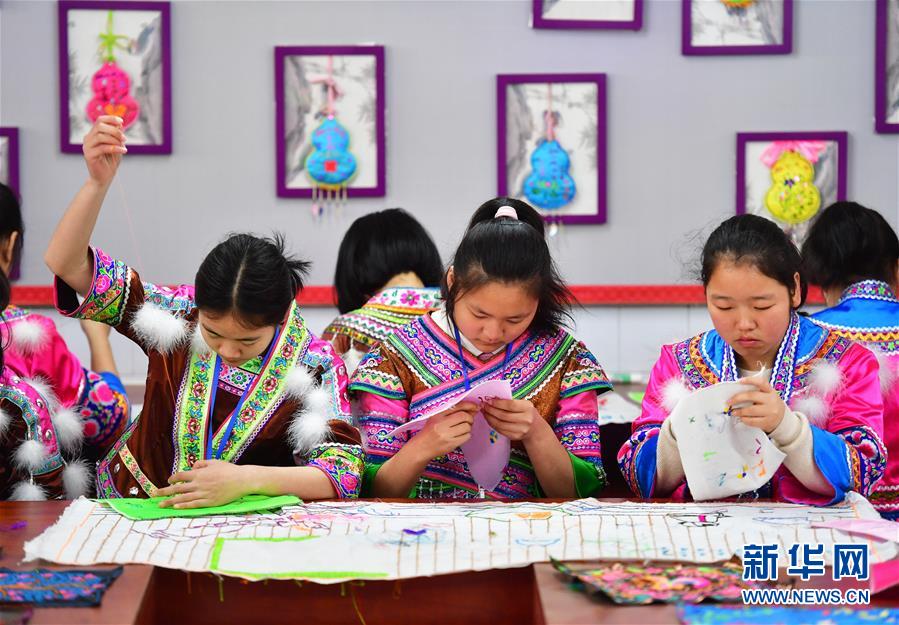 En una escuela segundaria del condado autónomo Miao de Rongshui, las alumnas asisten a una clase de bordado.