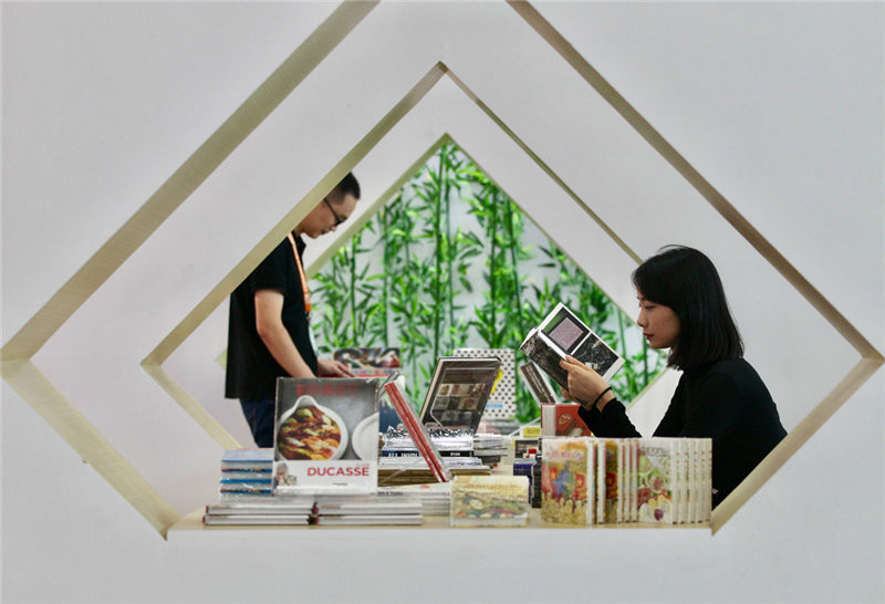 Visitantes leen libros en la XVI Exposición Internacional del Libro de Beijing, 21 de agosto del 2019. [Foto: Zhang Wei/ Chinadaily.com.cn]