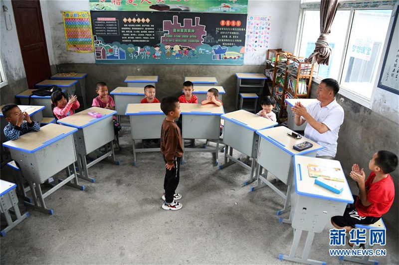 Wu Guoxian aplaude mientras su alumno canta en la clase de música, el 27 de agosto de 2019. [Foto / Xinhua]