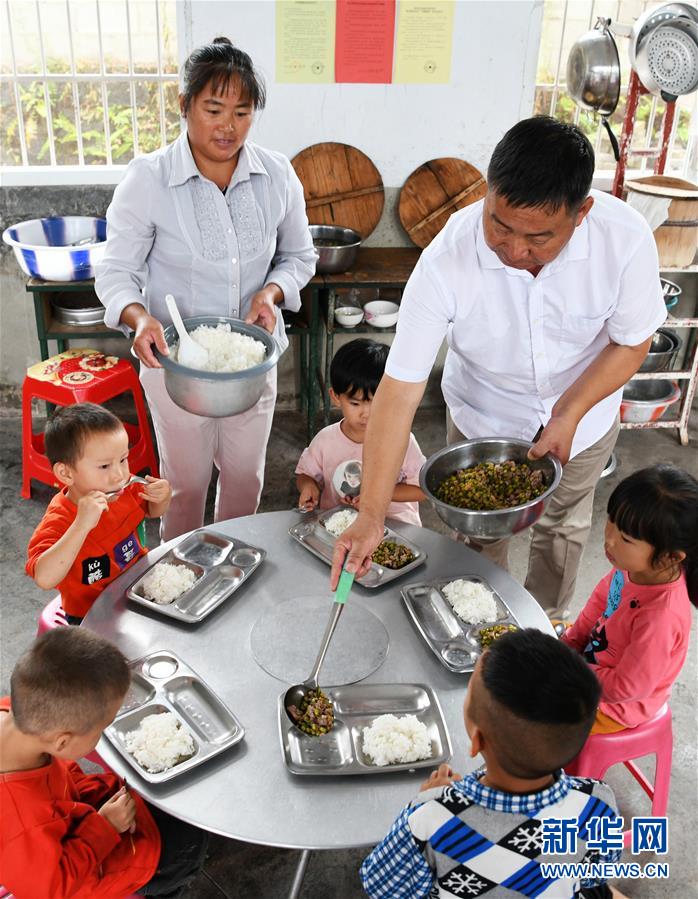 Wu Guoxian y su esposa dan almuerzo a los estudiantes de la Escuela Primaria Gugang, el 27 de agosto de 2019. [Foto / Xinhua]