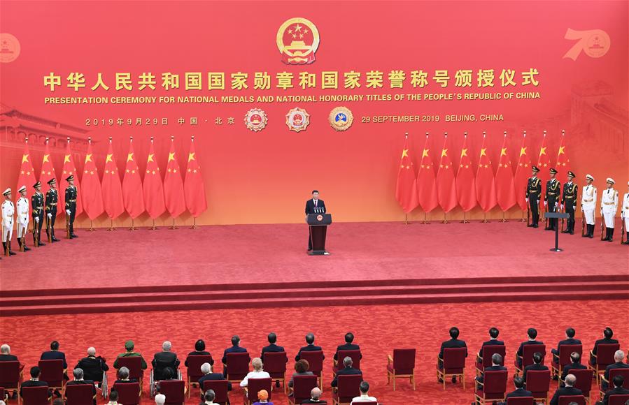 El presidente chino, Xi Jinping, también secretario general del Comité Central del Partido Comunista de China y presidente de la Comisión Militar Central, habla en la ceremonia de entrega de medallas nacionales y títulos honoríficos de la República Popular China en el Gran Palacio del Pueblo, en Beijing, capital de China, el 29 de septiembre de 2019. Xi entregó las medallas a los galardonados previo al discurso. (Xinhua/Yin Bogu)