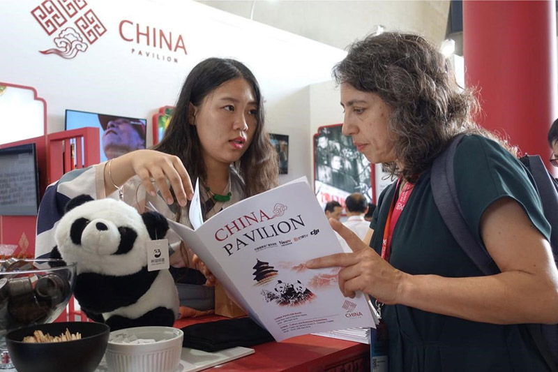 En la Conferencia sobre Innovación de Río de Janeiro de 2019, el pabellón de China exhibió productos culturales chinos, como programas de cine y televisión. La imagen muestra a la gente local escuchando al personal chino. Por Zhang Yuannan, Diario del Pueblo.
