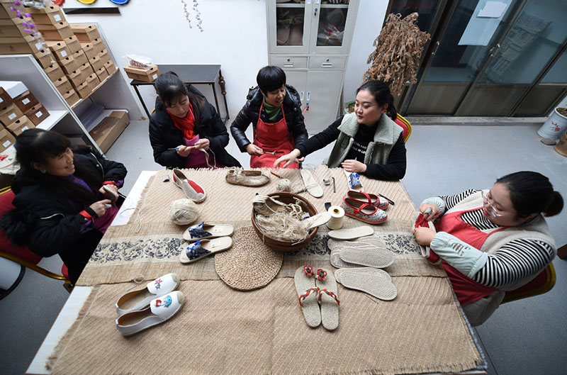 Guo Juan (segunda desde la derecha) fabrica zapatos con vecinas del pueblo en su fábrica en el condado Gangu, provincia de Gansu, noroeste de China, el 10 de enero de 2020. [Foto / Xinhua]