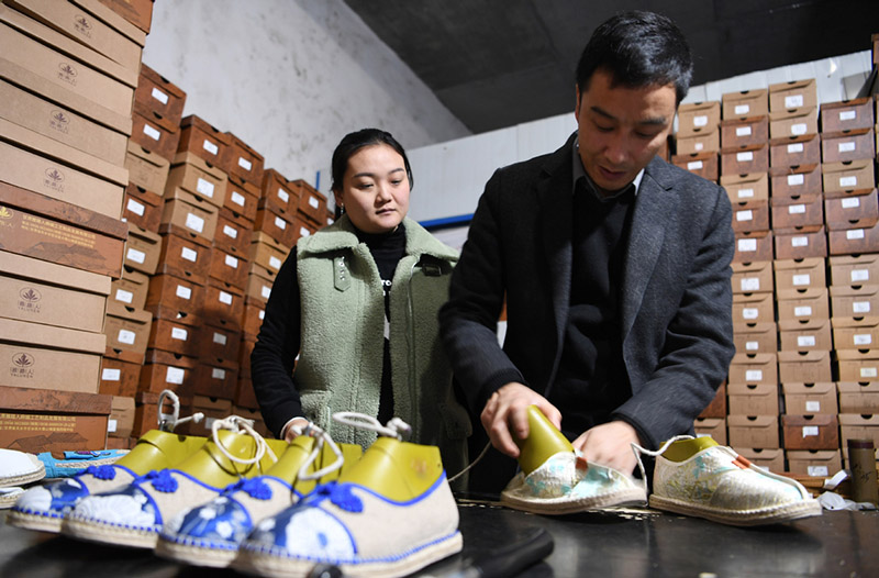 Niu Junjun y su esposa, Guo Juan, revisan los zapatos de cáñamo en su fábrica en el condado Gangu, provincia de Gansu, noroeste de China, el 10 de enero de 2020. [Foto / Xinhua]