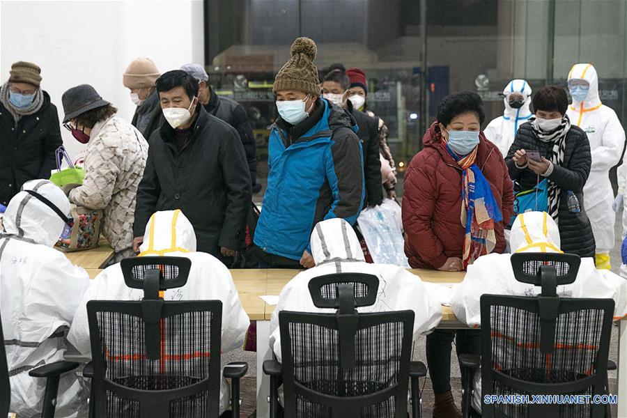WUHAN, 5 febrero, 2020 (Xinhua) -- Trabajadores médicos ayudan a los pacientes infectados con el nuevo coronavirus a registrarse en un hospital improvisado en Wuhan, provincia de Hubei, en el centro de China, el 5 de febrero de 2020. El primer hospital improvisado convertido de un centro de exposiciones en la ciudad de Wuhan afectada por la epidemia de China, comenzó a aceptar pacientes el miércoles. El hospital puede proporcionar aproximadamente 1.600 camas para pacientes infectados. (Xinhua/Xiong Qi)