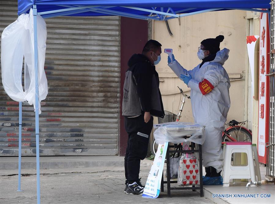 WUHAN, 11 febrero, 2020 (Xinhua) -- Imagen del 10 de febrero de 2020 de un trabajador del departamento gubernamental de Wuhan, quien labora como un inspector comunitario, midiendo la temperatura corporal de un visitante en la entrada de una manzana residencial en Wuhan, provincia de Hubei, en el centro de China. China ha intensificado sus esfuerzos para frenar la propagación del nuevo coronavirus. La provincia central de China, la provincia más afectada, reportó 2,097 nuevos casos confirmados y 103 nuevas muertes el lunes. (Xinhua/Li He)