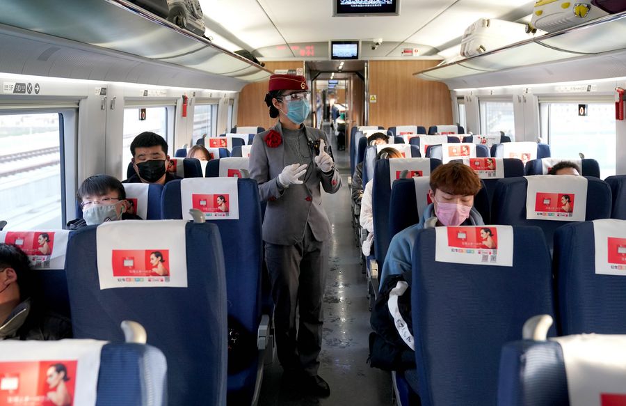 Una auxiliar de viaje presenta las medidas de prevención y control del nuevo coronavirus a los pasajeros a bordo de un tren adaptado que se dirige a la provincia de Zhejiang, en el este de China, el 22 de febrero de 2020. (Xinhua/Li An)