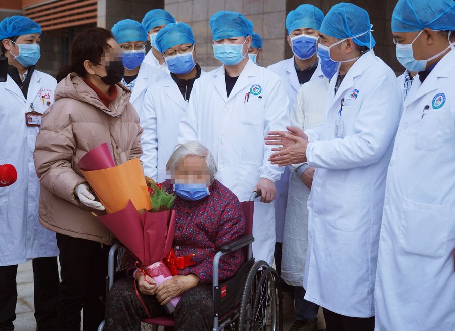 Trabajadores médicos dan consejos a la paciente curada, señora Liu (c-abajo), quien se recuperó de neumonía causada por el nuevo coronavirus en el Primer Hospital Afiliado a la Universidad de Nanchang, en Nanchang, provincia de Jiangxi, en el este de China, el 20 de febrero de 2020. (Xinhua/Wan Xiang)