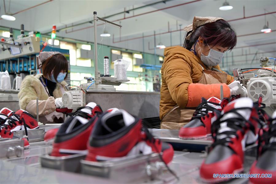 BEIJING, 26 febrero, 2020 (Xinhua) -- Imagen del 22 de febrero de 2020 de empleados trabajando en una fábrica de zapatos en el municipio Xiangtang del distrito de Nanchang, en la provincia de Jiangxi, en el este de China. (Xinhua/Peng Zhaozhi)