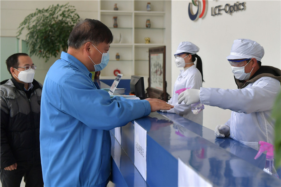 Un empleado de una empresa de tecnología electrónica se desinfecta las manos antes de ingresar a su lugar de trabajo en Nanchang, provincia de Jiangxi, 14 de febrero del 2020. [Foto: Xinhua]
