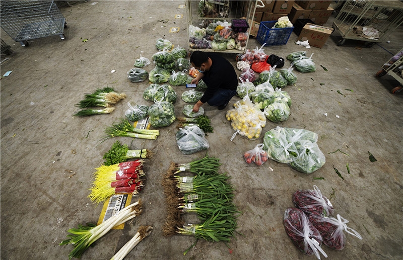 Ma Zengchen, repartidor de verduras, prepara los productos que tiene que entregar en Wuhan, provincia de Hubei, 7 de marzo del 2020. [Foto: Xinhua] 
