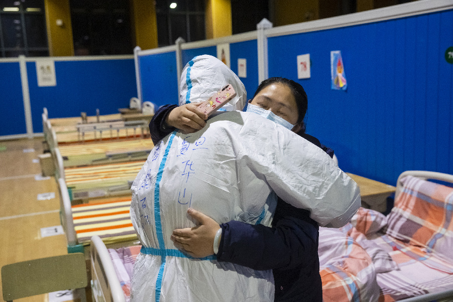 Una paciente recuperada de COVID-19 se despide de una enfermera al momento de ser dada de alta en el hospital provisional acondicionado en el interior del Gimnasio Hongshan, en Wuhan, el 9 de marzo de 2020. (Xinhua/Shen Bohan)