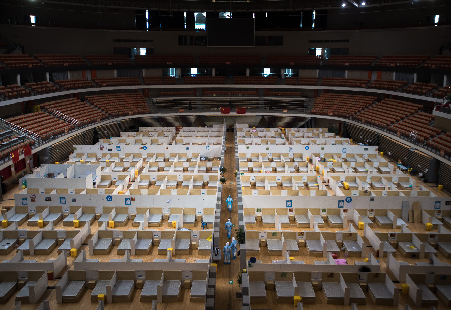 Empleados de servicios generales limpian un hospital provisional recién cerrado en Wuhan, el 8 de marzo de 2020. (Xinhua/Xiao Yijiu)