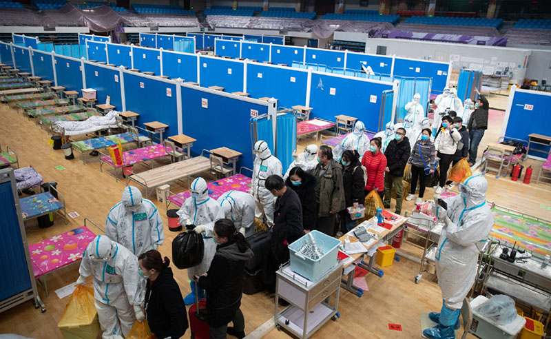 Los médicos ayudan a los pacientes con sus pertenencias el día del cierre del hospital improvisado de Wuchang, 10 de marzo del 2020. [Foto: Ke Hao/ Chinadaily] 