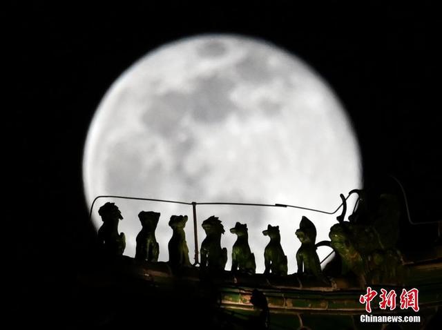 [Fuente: China News.com] Una " superluna " iluminó el cielo de Beijing. La imagen muestra un detalle del tejado de la Torre Zhengyangmen con la luna detrás. Por Mao Jianjun, Agencia de Noticias de China.