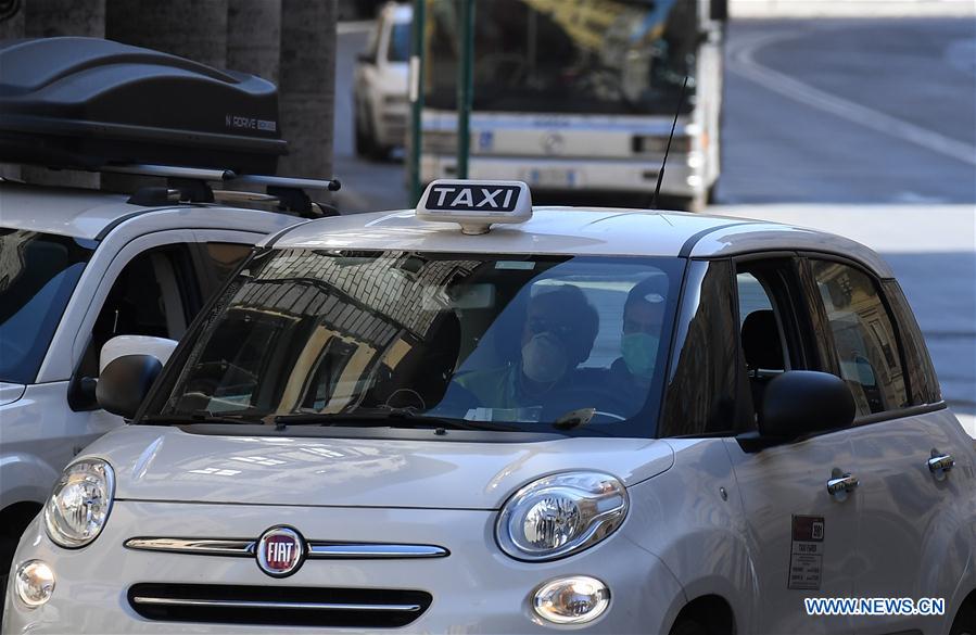 ROMA, 12 marzo, 2020 (Xinhua) -- Personas portando mascarillas viajan abordo de un taxi, en Roma, Italia, el 12 de marzo de 2020. El primer ministro de Italia, Giuseppe Conte, anunció la noche del miércoles el cierre de todas las tiendas minoristas, cafeterías, pubs, restaurantes, estéticas y salones de belleza y pidió al sector privado permitir a los empleados ausentarse o trabajar desde casa en la medida de lo posible. (Xinhua/Elisa Lingria)