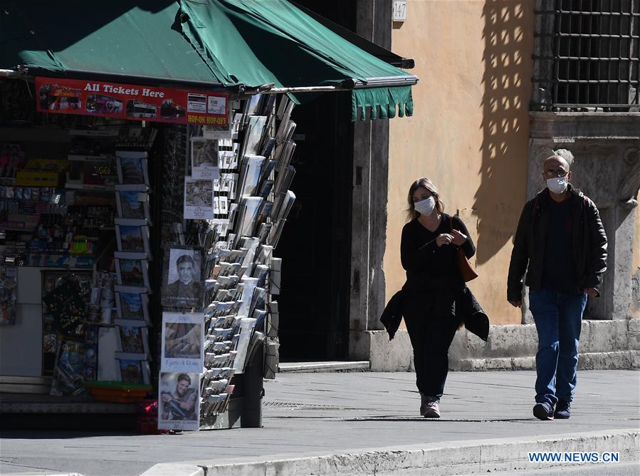 ROMA, 12 marzo, 2020 (Xinhua) -- Personas portan mascarillas mientras caminan en una calle de Roma, Italia, el 12 de marzo de 2020. El primer ministro de Italia, Giuseppe Conte, anunció la noche del miércoles el cierre de todas las tiendas minoristas, cafeterías, pubs, restaurantes, estéticas y salones de belleza y pidió al sector privado permitir a los empleados ausentarse o trabajar desde casa en la medida de lo posible. (Xinhua/Elisa Lingria)