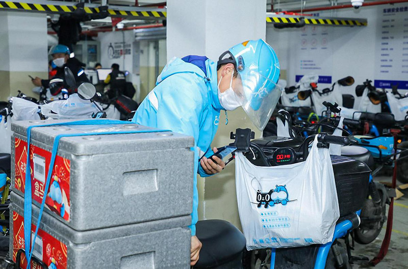 Un repartidor de Hema escanea las etiquetas de los paquetes con un dispositivo de alta tecnología para obtener información sobre los puntos de entrega en Hangzhou, provincia Zhejiang, 31 de enero del 2020. [Foto: Niu Jing/ China Daily] 