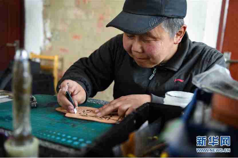 Un hombre en la ciudad de Xinihe, territorio autónomo de Ewenki en Mongolia Interior, tallaba productos de cuero, el 15 de abril de 2020. (Foto de Liu Lei / Xinhua)