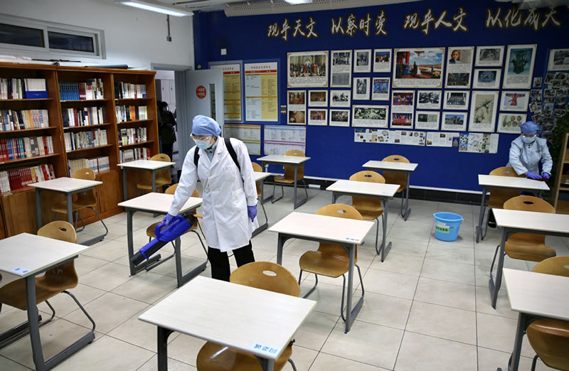 Un empleado de la Escuela del Día Nacional de Beijing desinfecta un aula de tercer curso, el 21 de abril de 2020. [Foto por Zuo Hong / chinadaily.com.cn]