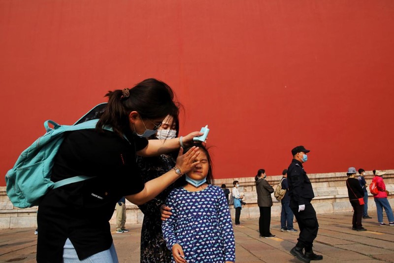 Una visitante ayuda a su hija a ponerse protector solar en el Museo del Palacio de Beijing, el 1 de mayo de 2020. [Foto de Jiang Dong / China Daily]