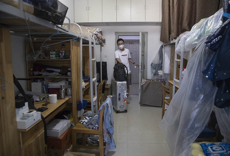 Un estudiante entra a su dormitorio compartido de la Universidad de Wuhan, provincia de Hubei, 8 de junio del 2020. [Foto: Ke Hao/ China Daily]