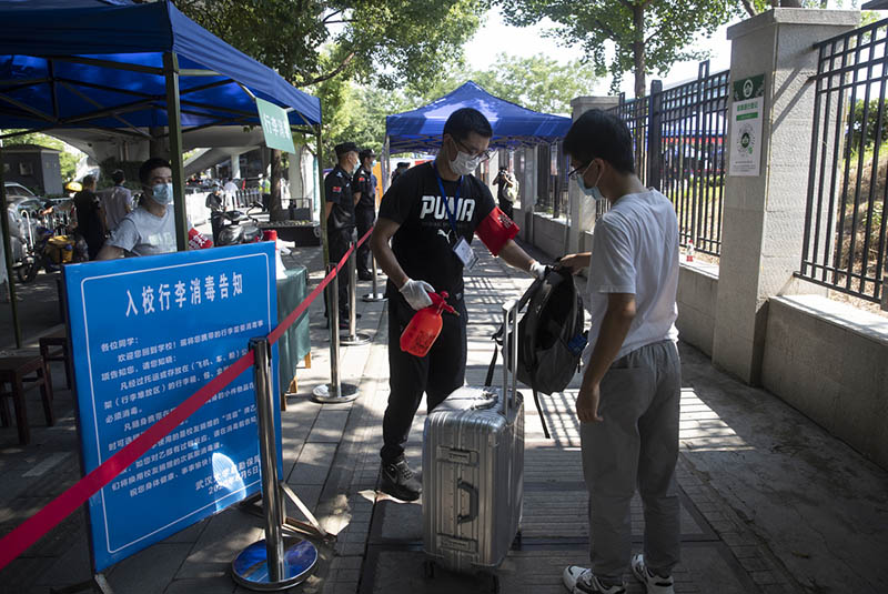 Un trabajador desinfecta el equipaje de un estudiante de la Universidad de Wuhan, provincia de Hubei, 8 de junio del 2020. [Foto: Ke Hao/ China Daily]