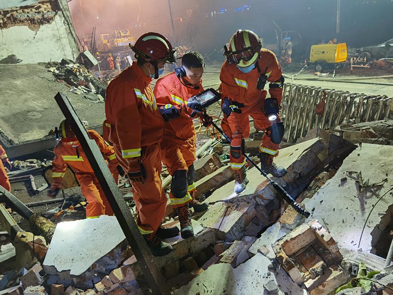 Los bomberos de la Brigada de Bomberos de Wenzhou buscan debajo de los escombros en el lugar de la explosión de un camión cisterna en Zhejiang. [Foto proporcionada a China Daily]
