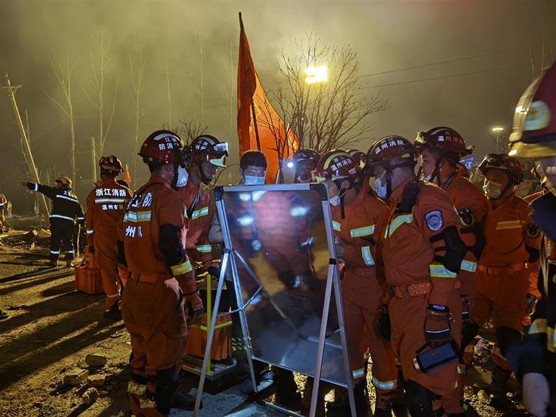 Los bomberos de la Brigada de Bomberos de Wenzhou buscan debajo de los escombros en el lugar de la explosión de un camión cisterna en Zhejiang. [Foto proporcionada a China Daily]