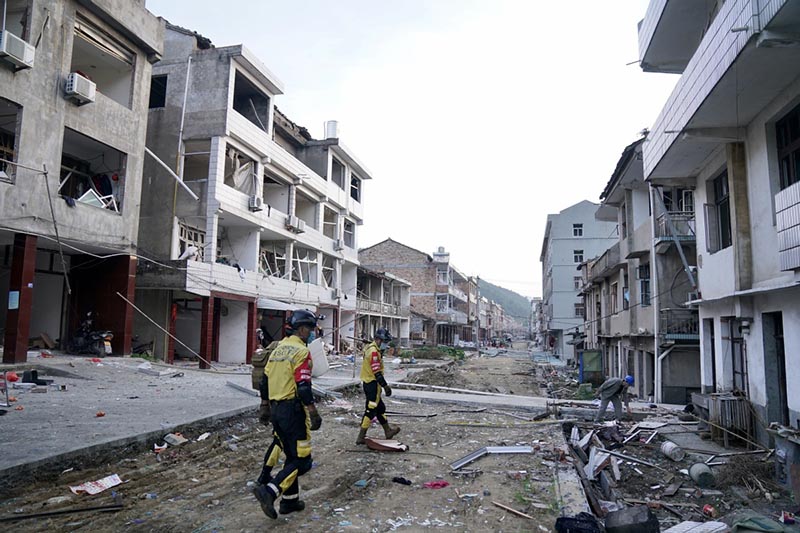 Miembros del equipo de rescate entran en un edificio dañado en el lugar de la explosión de un camión en Zhejiang. [Foto proporcionada a China Daily]