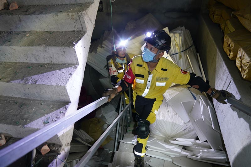 Miembros del equipo de rescate entran en un edificio dañado en el lugar de la explosión de un camión en Zhejiang. [Foto proporcionada a China Daily]