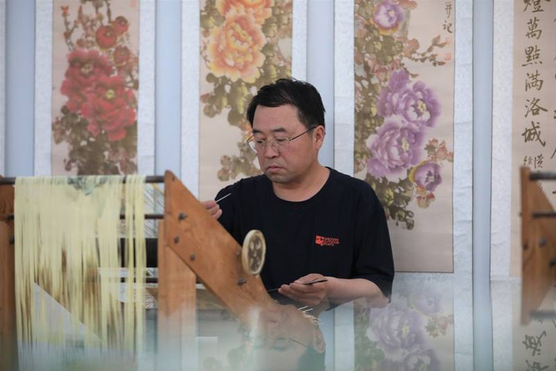 El maestro Wei trabaja en una pintura de papel tejido, condado Zhuanglang, ciudad de Pingliang, provincia de Gansu, 8 de julio del 2020. [Foto: Xinhua]