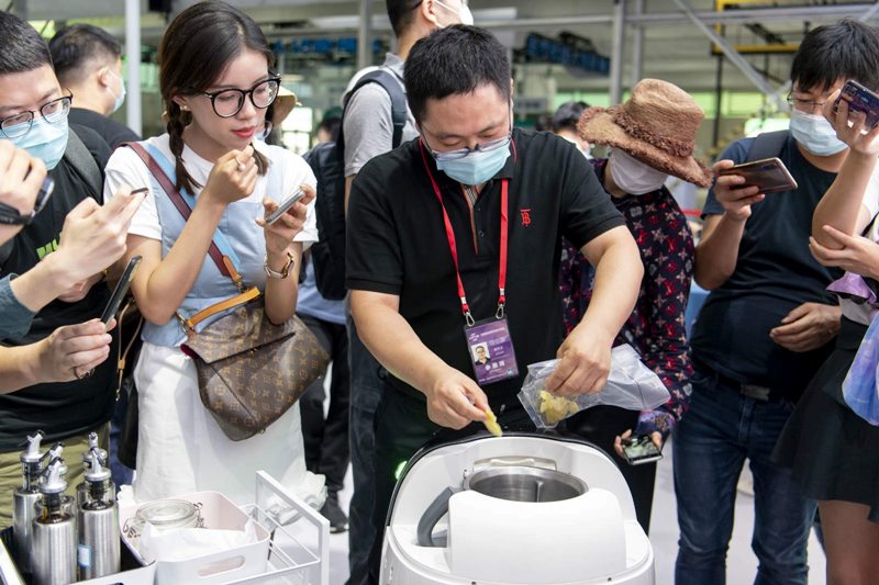 El 1 de septiembre, un expositor mostró un robot de cocina a los periodistas en la sala de exhibición de servicios robóticos de la Feria Internacional de Comercio de Servicios. Por Weng Qiyu / vip.people.com.cn
