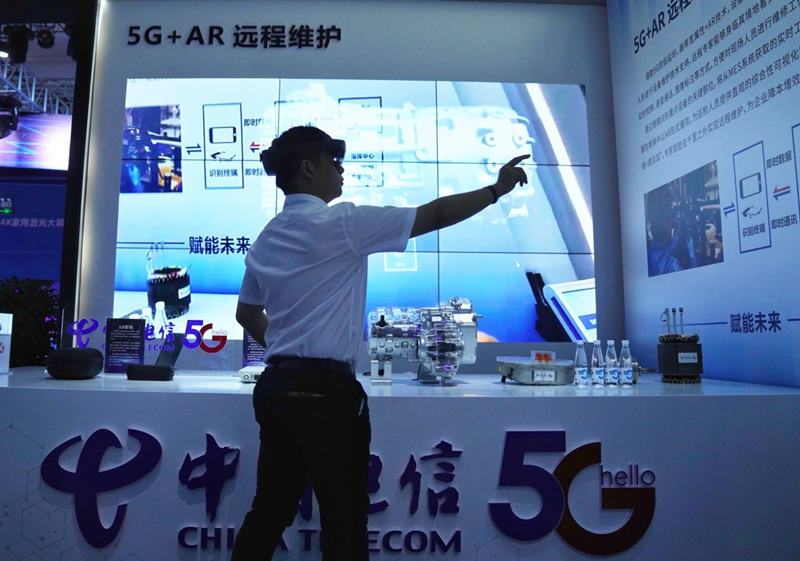 Un visitante experimenta el control remoto con 5G+AR. Foto de Luo Jia