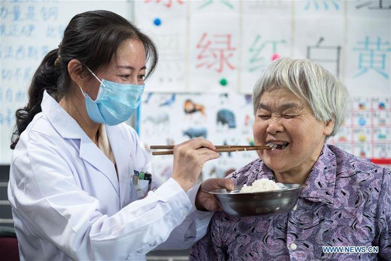 Un trabajador de la salud asiste a un anciana discapacitada en la residencia geriátrica del Hospital Longhui-Weiyuan, condado de Longhui, provincia de Hunan, 12 de octubre del 2020. Para elevar la calidad de la atención al adulto mayor, la unidad geriátrica proporciona servicios de enfermería, rehabilitación, entretenimiento y alimentación. (Fotos: Xinhua)