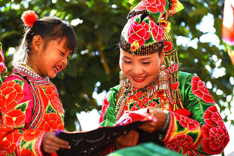 Mujeres de la etnia Yi, de la prefectura Dali, provincia de Yunnan, bordan prendas tradicionales. Estos artículos, cuya tradición se ha transmitido durante miles de años, se venden bien en China y en el extranjero. Esta singular artesanía se ha convertido en una nueva industria para que las mujeres locales aumenten sus ingresos y puedan salir de la pobreza, 6 de diciembre del 2020.  (Foto: Zhang Shulu/ Pueblo en Línea)