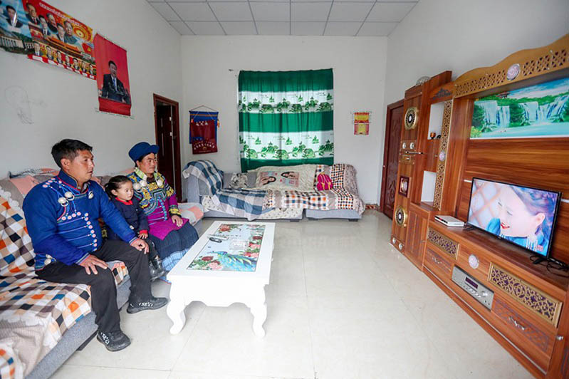 Un aldeano llamado Ayuehuori está viendo televisión con su familia en su nuevo hogar de un sitio de reasentamiento de la prefectura autónoma de Liangshan, 12 de septiembre de 2020. (Foto: Qiu Haiying/ Pueblo en Línea)