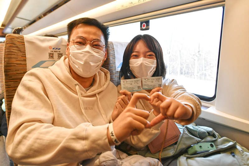 Los pasajeros se hacen fotos con sus billetes de tren en el primer ferrocarril que une Beijing y la Nueva Área de Xiong´an, en la Estación de Ferrocarriles Oeste de Beijing, el 27 de diciembre de 2020. [Foto de Sun Lijun / chinadaily.com.cn]