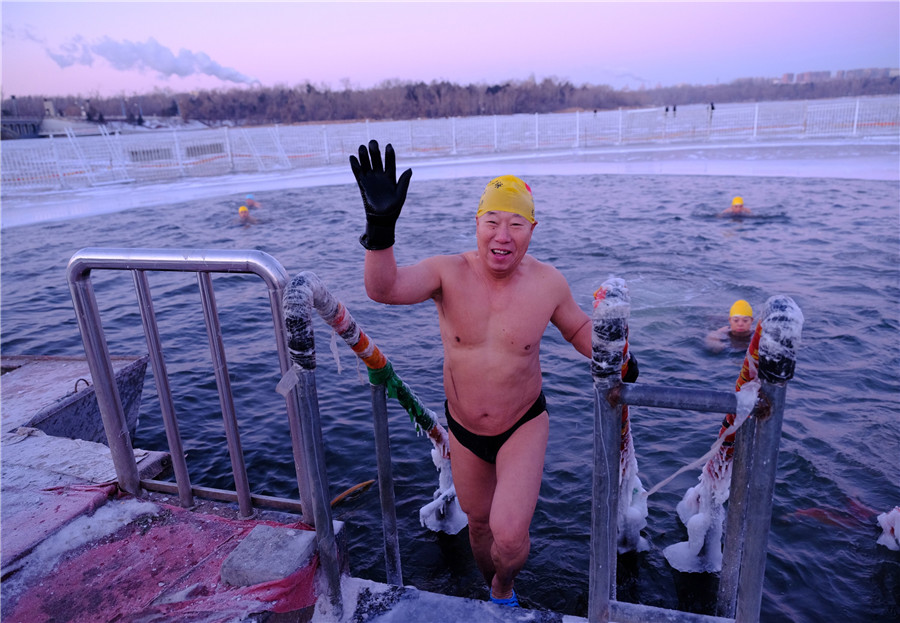 Un entusiasta de la natación invernal saluda después de salir del lago helado de Nanhu. [Foto de Bai Shi / para chinadaily.com.cn]